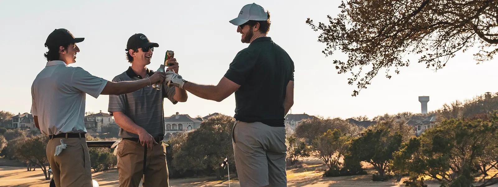 Men golfing and toasting each other with canned bear