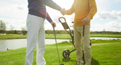 Two golfers shaking hands on the golf course