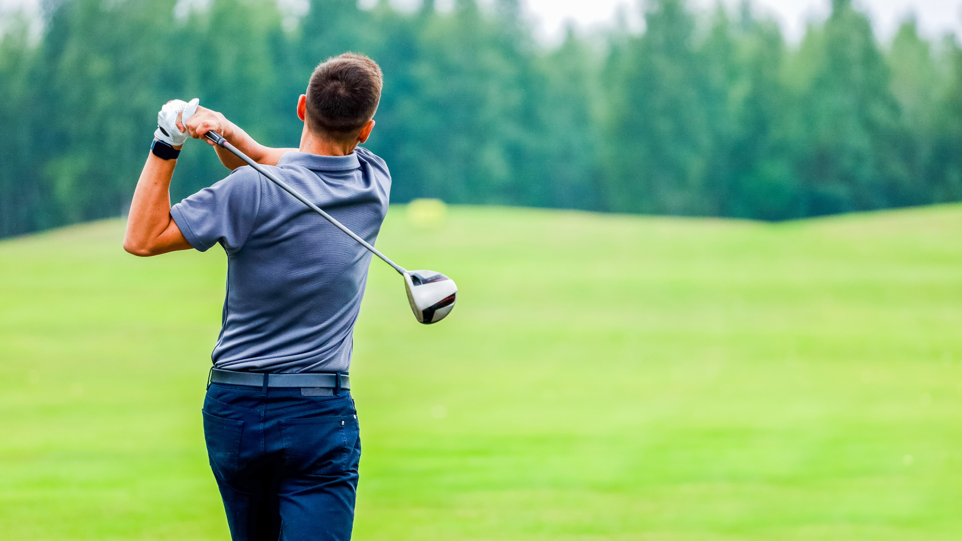 Golfer at the end of his swing on the golf course