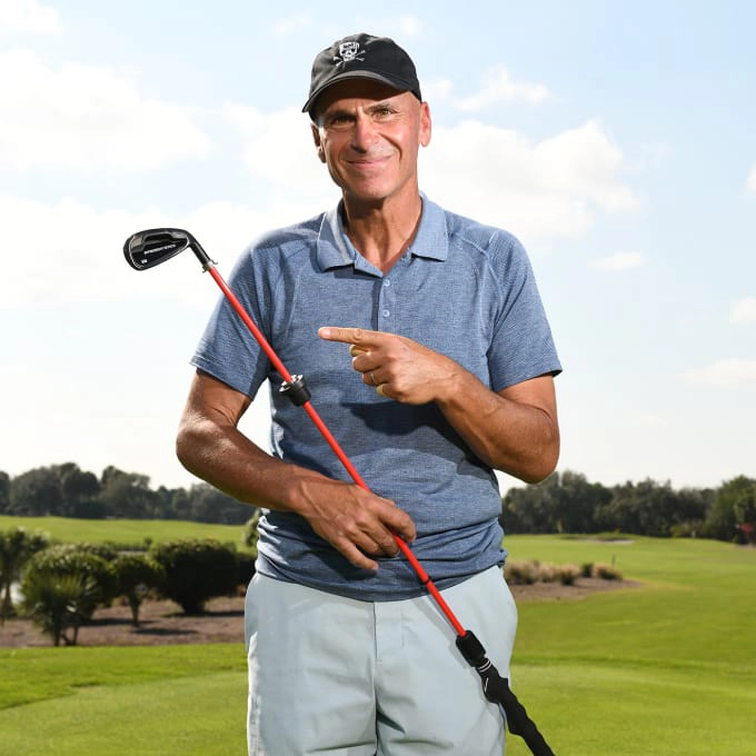 Rocco Mediate holding the straight stick golf club trainer and pointing to it