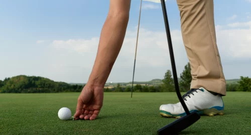 Golfer placing a ball on the greens