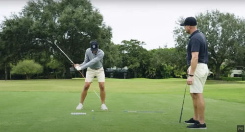 Two golfers practicing a contact drill.