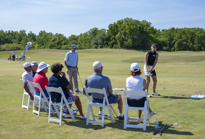 Performance Golf's Erika Larkin giving a tutorial at a Performance Golf VIP School training session with a group of 6 golf students.