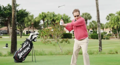 A high handicap golfer using The Hinge training aid, receiving physical feedback on their open clubface in the golf swing.