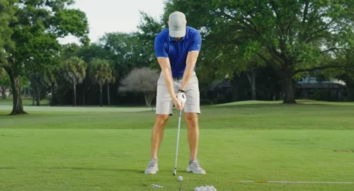 A golfer on the golf course, setting up with the right golf swing stance, grip and position.