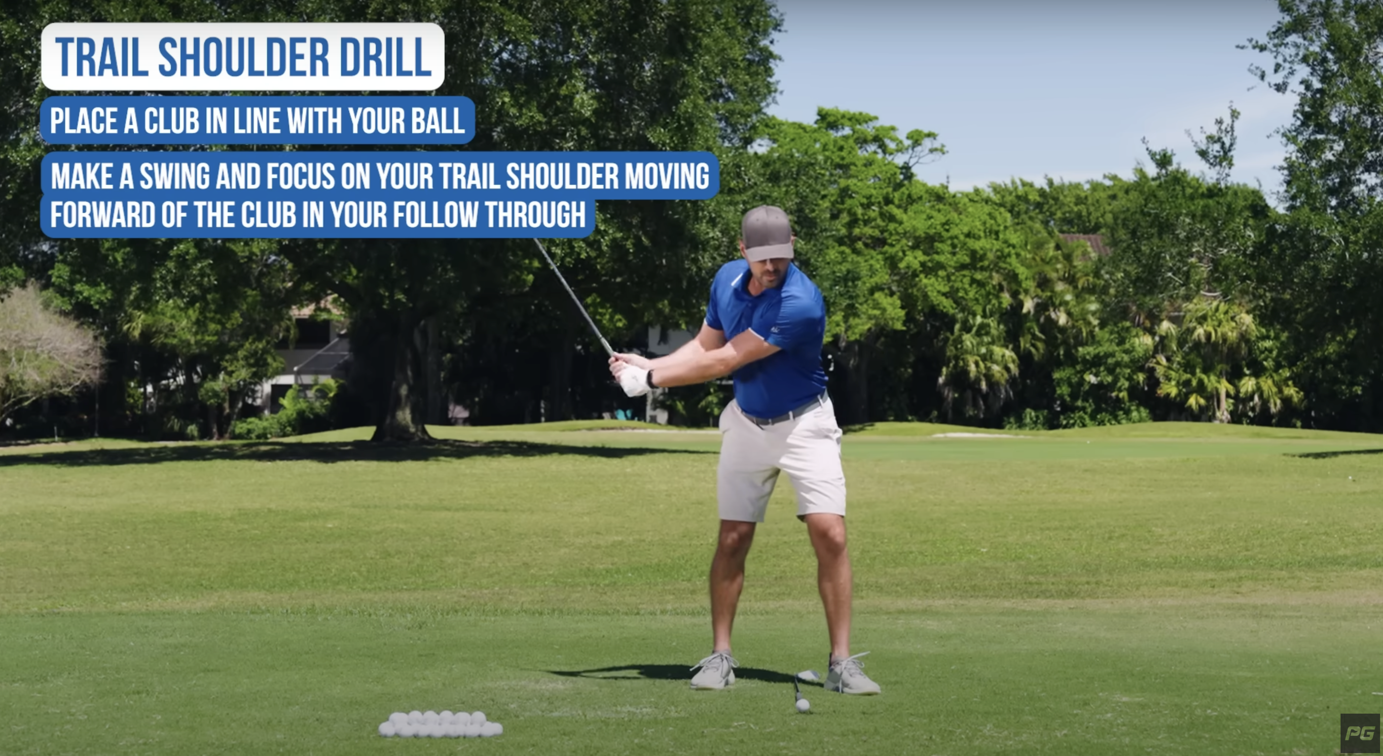 Performance Golf coach Eric Cogorno has a golf club on the ground and is showing how to perform a trail shoulder golf swing drill.