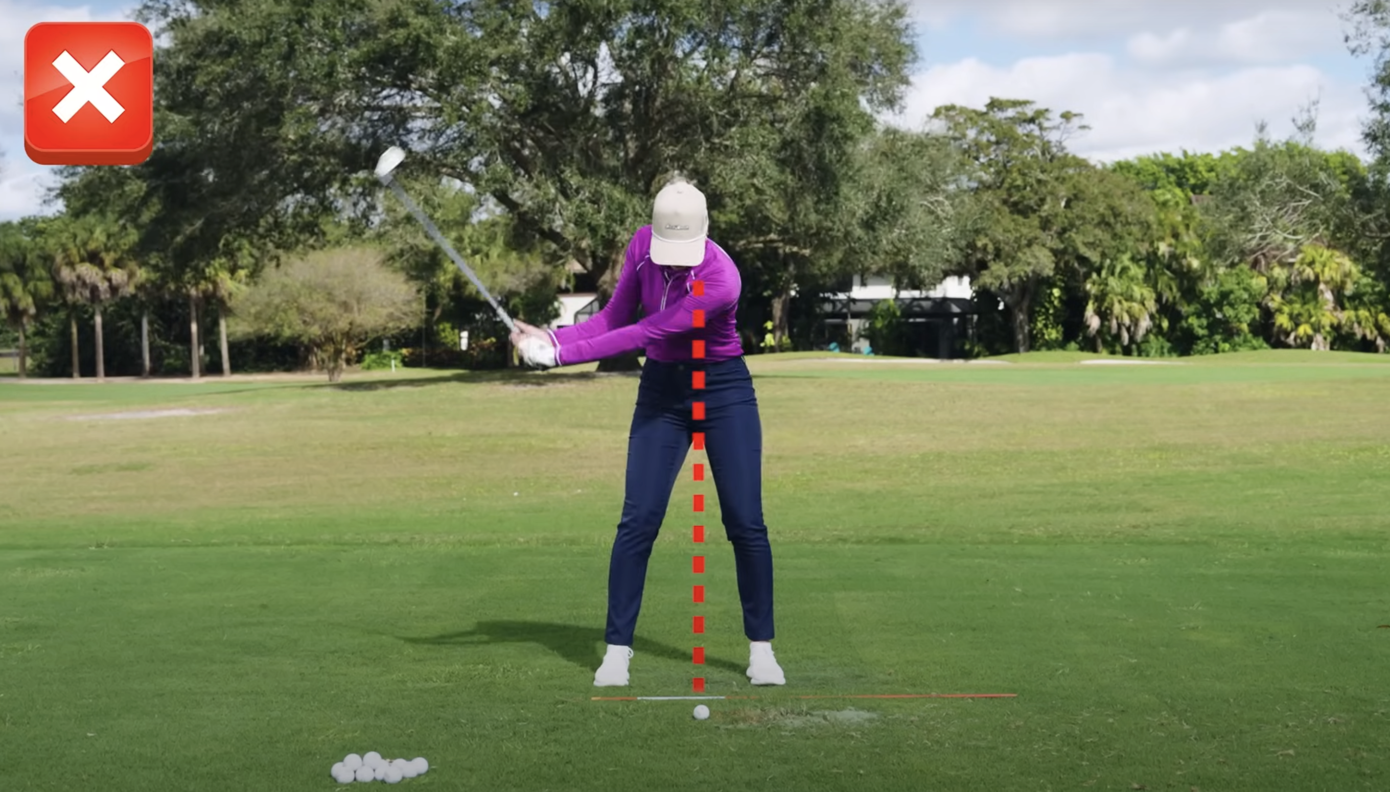 Performance Golf coach looking down at the ball in the backswing, with a red dotted line showing the ball position is incorrect.